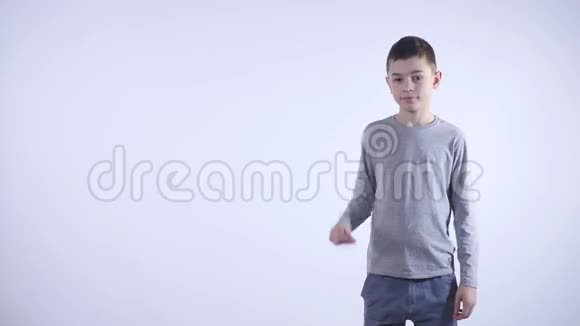一个微笑的小男孩在白色背景下向旁边伸出手指视频的预览图