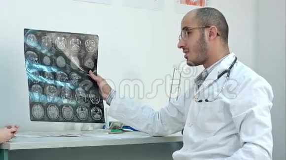 微笑医生向病人展示脑部计算机断层扫描x射线图像视频的预览图
