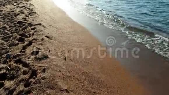 4k摄像机拍摄日落时在平静的海浪和沙滩上飞行视频的预览图