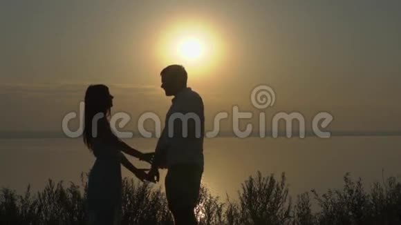 幸福的年轻夫妇在日落时在海边跳舞爱的概念视频的预览图