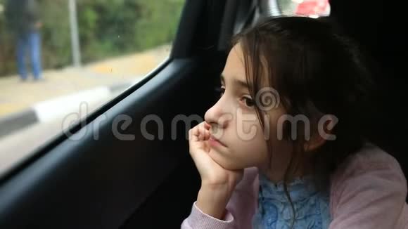 无聊的小女孩坐在车里透过窗户凝视着太空路过的树木的巨大倒影视频的预览图
