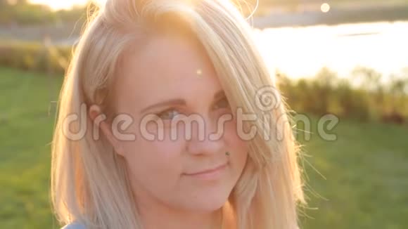 傍晚阳光下一个金发女孩美丽的脸庞视频的预览图