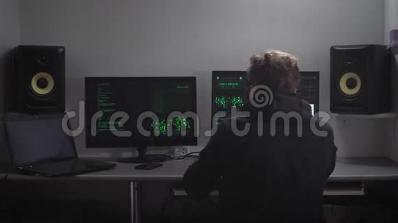 年轻的黑客金发穿着黑色衣服坐在地下掩体里写程序监视其他人视频的预览图
