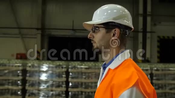 戴着安全帽的工人穿过仓库视频的预览图