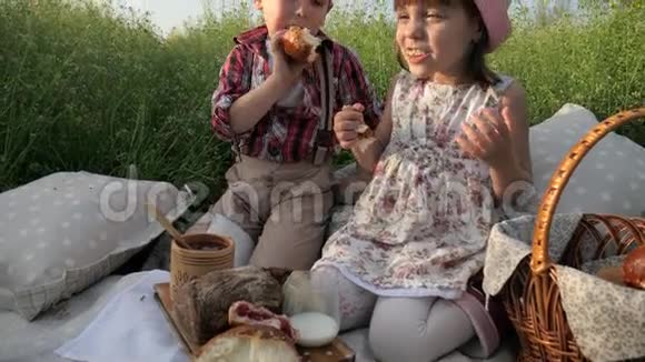 可爱的孩子们分享面包男孩用面包店的产品喂养女孩野餐的产品孩子们玩得开心视频的预览图