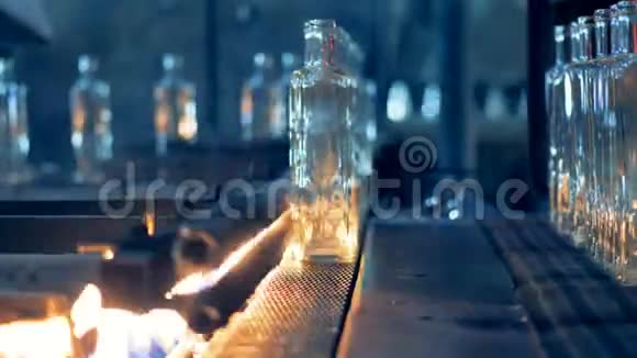 玻璃瓶用火焰在传送带上加热以进行巴氏杀菌4K视频的预览图