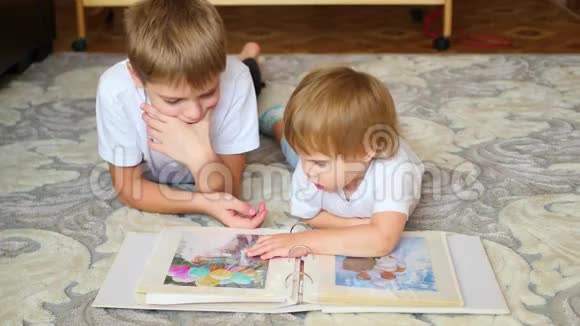 孩子们看家庭相册的照片视频的预览图