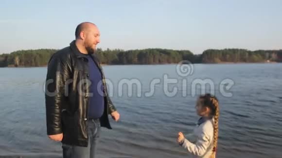 胖爸爸和胖女儿在河边海边海边玩得很开心视频的预览图
