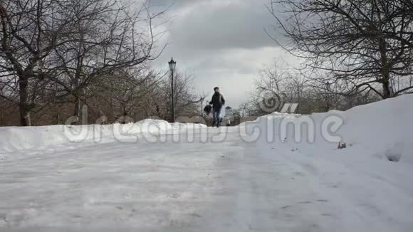 穿着背包跑在冬季公园的快乐女孩视频的预览图