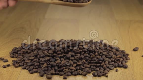 手迅速地将咖啡豆从木勺中倒入一堆咖啡豆上视频的预览图