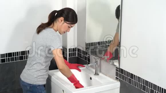 女人用刷子清洗浴室水槽视频的预览图