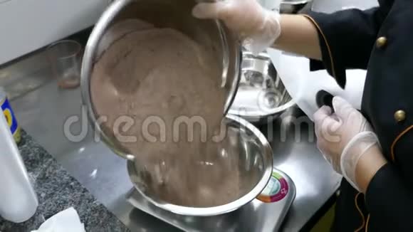一个糖果师把面粉放入一个精确的碗中并测量它的重量视频的预览图
