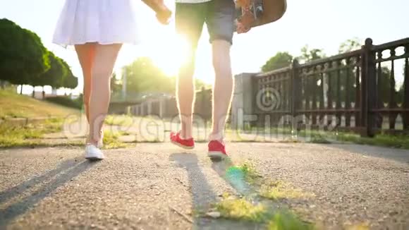 恋爱中的年轻夫妇在日落时沿街散步慢动作视频的预览图