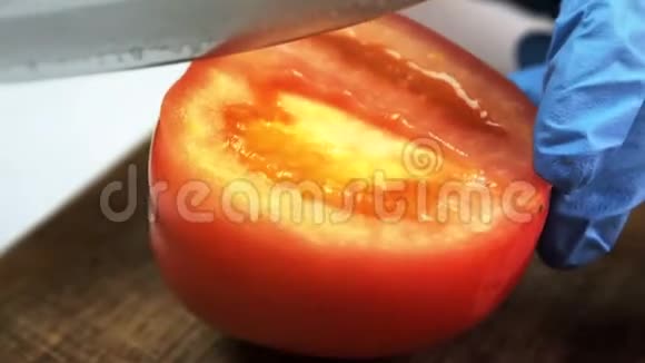 用手套刀将熟番茄切在木板上视频的预览图
