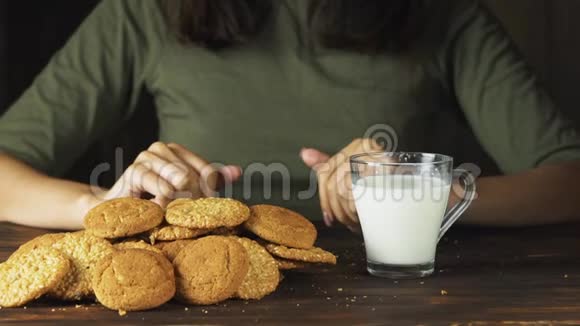 用手慢慢地把一块饼干放进一杯牛奶里食物电影场景视频的预览图