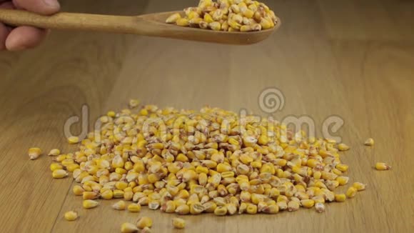 手很快把木勺上的玉米粒倒入一堆玉米上视频的预览图