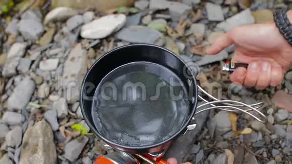 在一次旅游露营中男人的手把鸡蛋打碎成煎锅视频的预览图