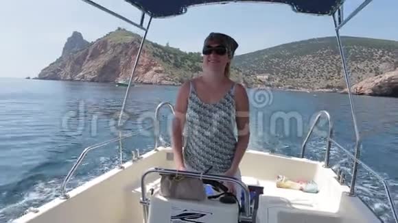 站在摩托艇上掌舵的年轻女子海洋视频的预览图