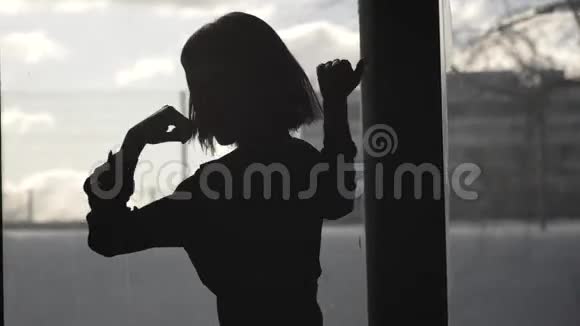 一个快乐女孩在窗前跳舞的剪影视频的预览图