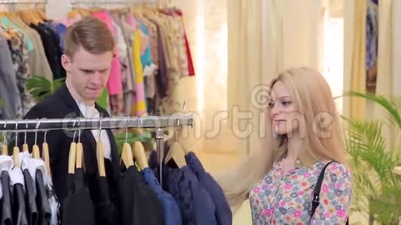 年轻漂亮的女人和男朋友一起选择服装店视频的预览图