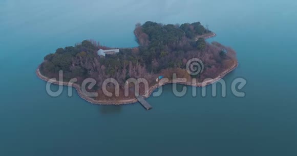 日落时分在蓝水湖中央的岛屿上空盘旋视频的预览图