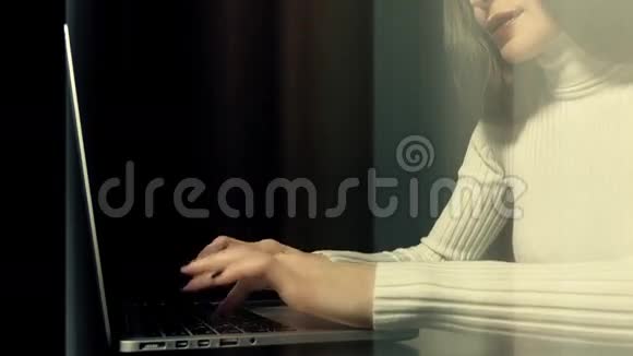 美丽的黑发女人在她的笔记本电脑上工作的黑色背景未来的抽象光线垂直线移动视频的预览图