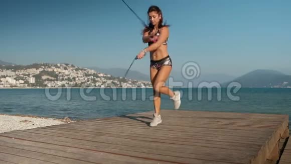 女人用两根跳绳跳在海滩上做运动视频的预览图