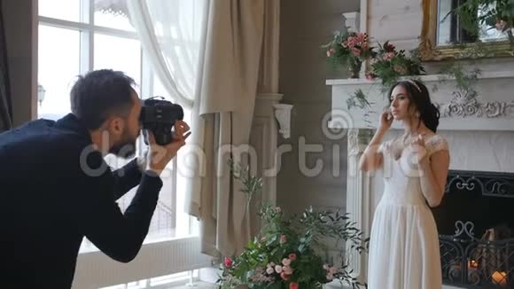 摄影师用一个背景上带壁炉的中型电影摄影机拍摄新娘视频的预览图