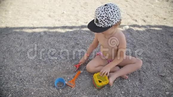 快乐的小女孩在海滩上玩弹珠在海滨的孩子海边的夏天视频的预览图