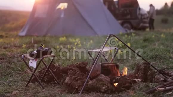 乘车旅行的营地背景上有凯特勒和帐篷的篝火视频的预览图