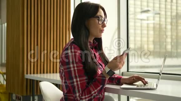 年轻的混血时髦女人拿着信用卡用手提电脑视频的预览图
