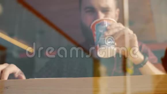 一个男人坐在咖啡馆里拿着智能手机喝着咖啡视频的预览图