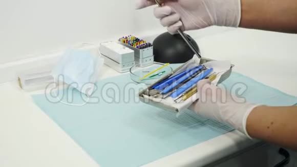 双手放在手套上桌子上放着牙科镜和托盘上的挖掘机视频的预览图