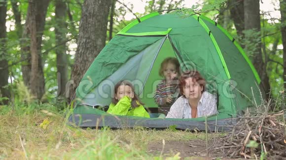 孩子们在绿色的帐篷里玩耍在森林的空地上玩耍视频的预览图