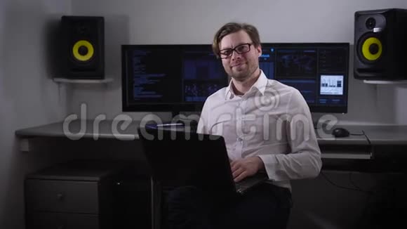 查看一个快乐而周到的编程办公室工作人员谁冻结在原地他手里拿着一台笔记本电脑坐着视频的预览图