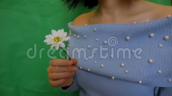 一个美丽迷人的女孩吸入了一朵花的芬芳白色的伪装视频的预览图