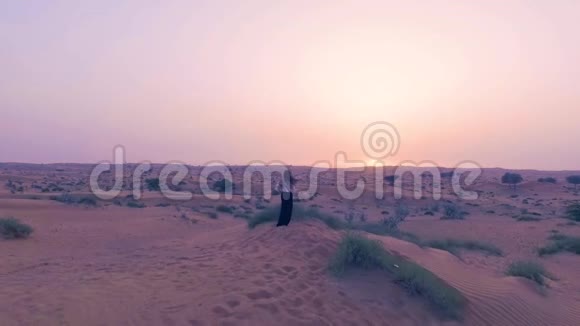 美丽的女孩在沙漠中跳舞背景是阳光快乐美丽的女人在日落时在沙滩上跳舞视频的预览图