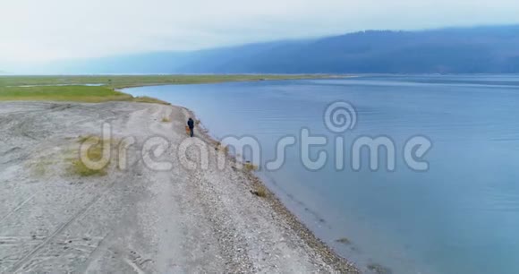 一个人带着他的狗在湖边走4k视频的预览图