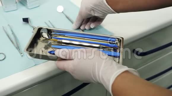 双手放在手套里从桌子上拿出牙科工具视频的预览图
