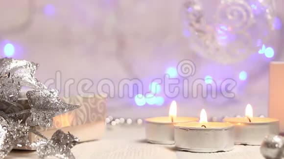 燃烧蜡烛和一个悬挂的圣诞球背景是明亮的蓝色灯笼大规模的计划视频的预览图
