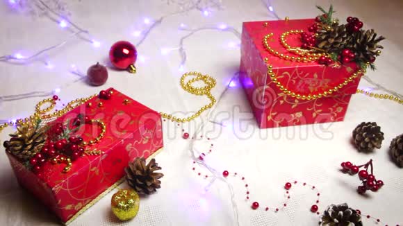 送给其他礼物的红色礼物上面有闪烁的花环和圣诞树玩具视频的预览图