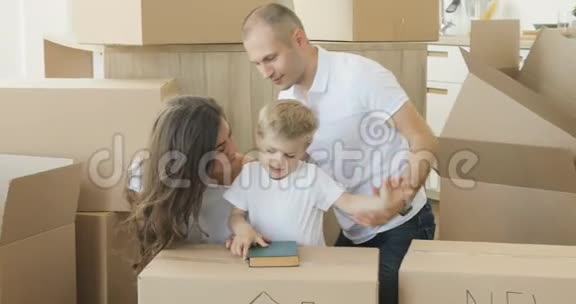 家人在他们的新公寓里玩家庭搬家家庭放松和欢笑后打开纸箱从视频的预览图