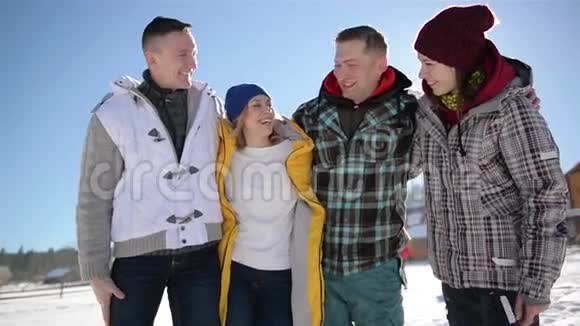 四个朋友在蓝天背景下互相拥抱冬季两对幸福夫妇的特写肖像视频的预览图