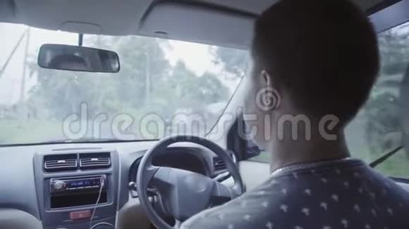成熟的白种人短发男子驾驶右手驾驶汽车在农村道路视频的预览图
