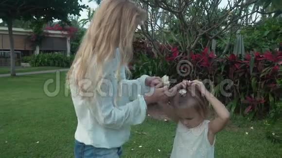 妈妈用梅花花装饰女儿头发慢动作股票录像视频的预览图