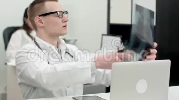 年轻的男医生检查x光图像视频的预览图