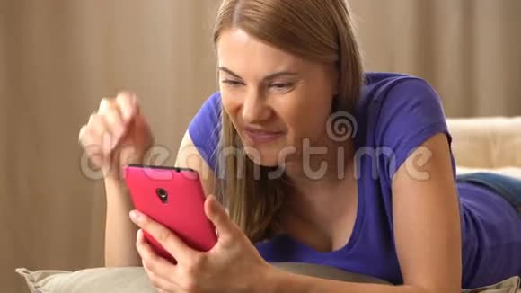 美丽迷人的年轻女子穿着紫罗兰色的t恤通过一个混乱的人与朋友交流视频的预览图