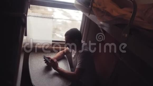 男子剪影商人与智能手机旅行火车男人旅行者与智能手机打字网络视频的预览图