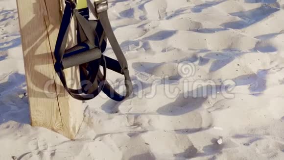 特写环健身TRX系统的手柄TRX悬挂带在沙子的背景下在海滩上视频的预览图