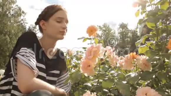 女孩用镜头耀斑嗅玫瑰视频的预览图